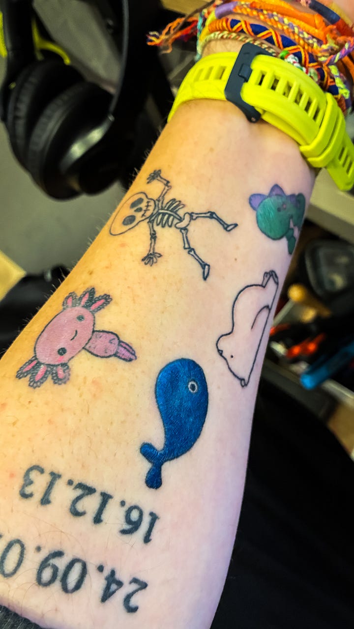 A tattoo of a pin badge design on a forearm.